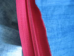 Do górnej części z haftem przymocujemy szpilkami zamek błyskawiczny